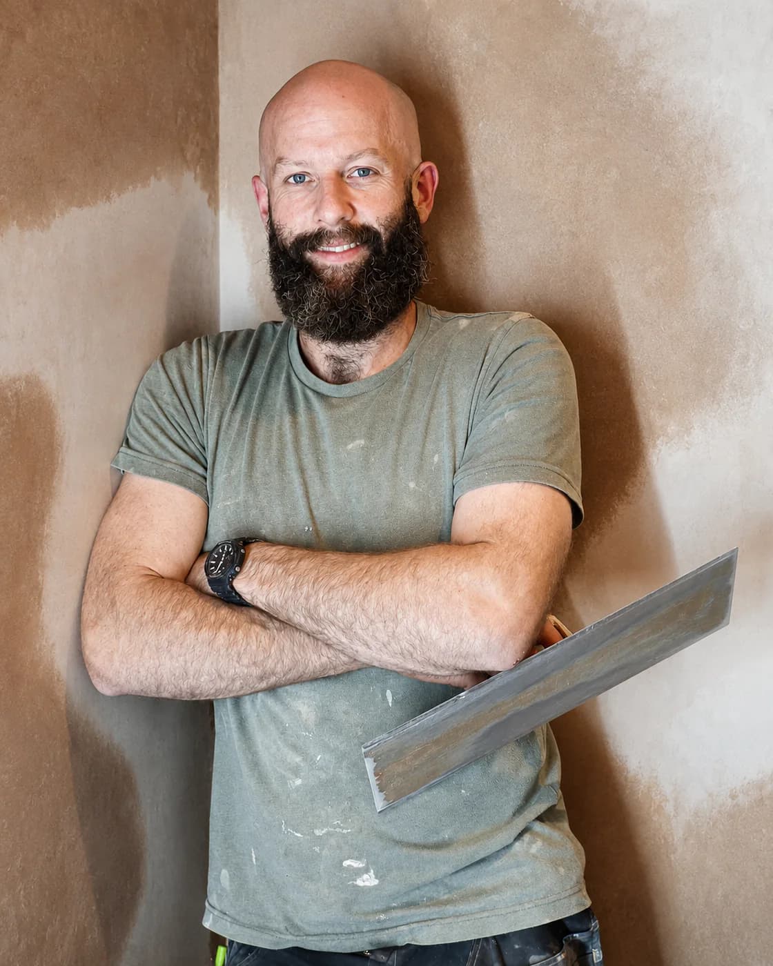 Sam, the plasterer behind SJT Plastering, holding a plastering trowel